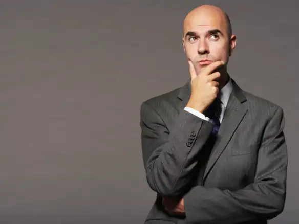 Professional man wearing gray suit posing thoughtfully for corporate portrait