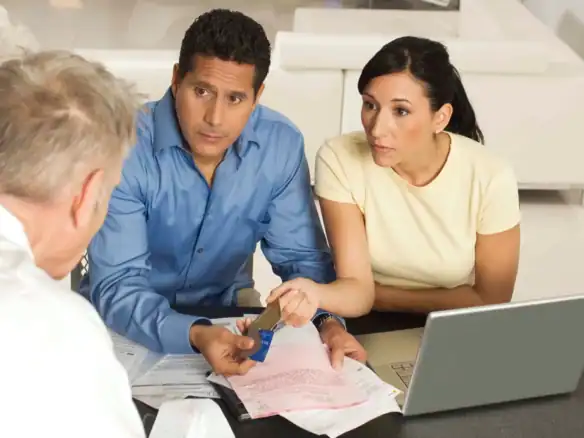 Advisor consulting couple about financial planning, bills, and money management.
